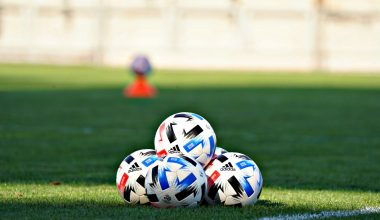 white blue and red soccer ball on green grass field during daytime