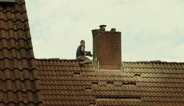 a man on a roof with a bird flying overhead