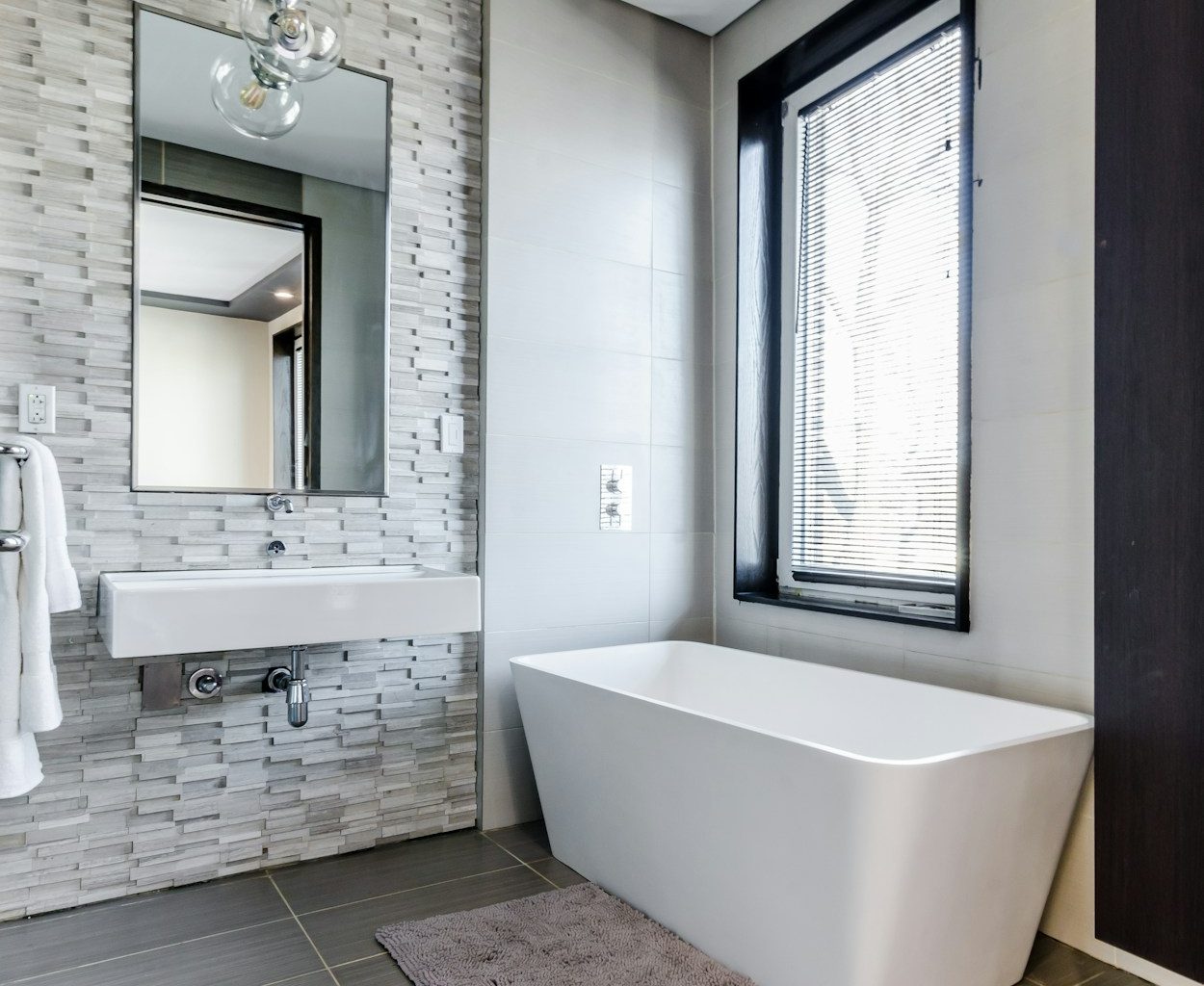 white ceramic bathtub near white framed window