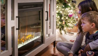 woman in gray long sleeve shirt sitting on floor beside fireplace