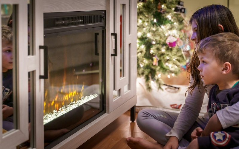 woman in gray long sleeve shirt sitting on floor beside fireplace