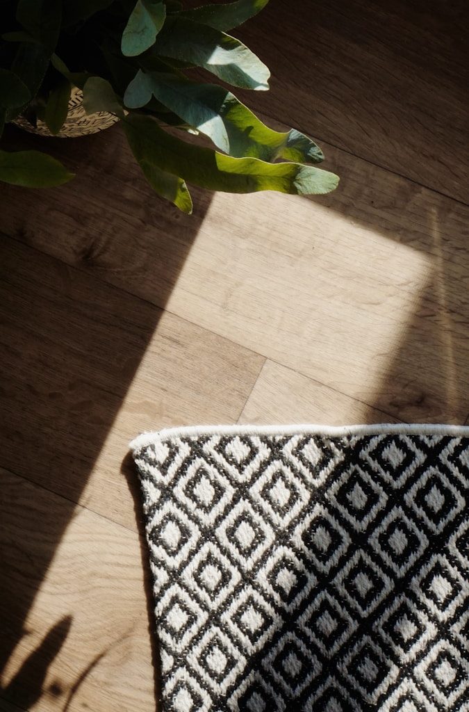 a vase of flowers sitting on top of a wooden floor