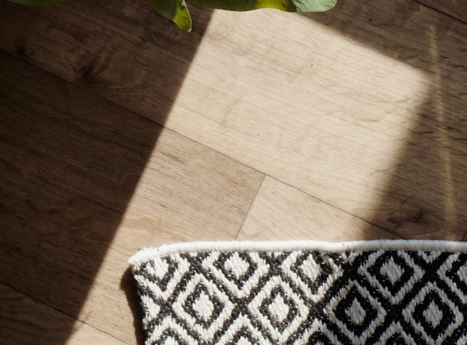 a vase of flowers sitting on top of a wooden floor