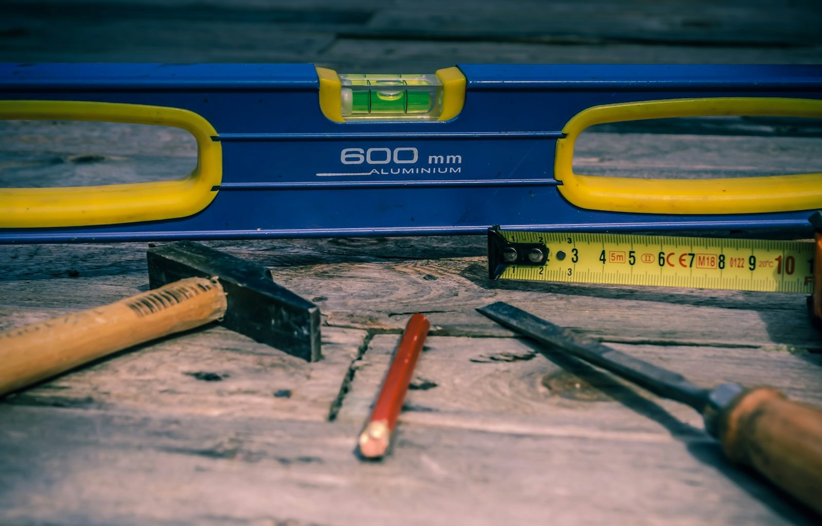 orange pen beside blue tape dispenser