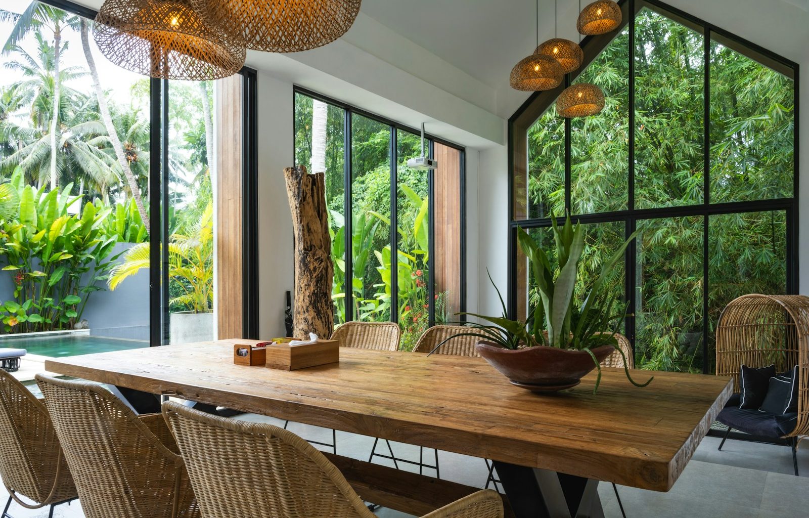 A dining room with a large wooden table surrounded by chairs