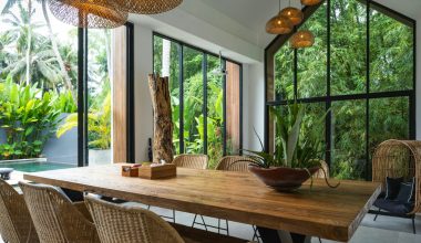 A dining room with a large wooden table surrounded by chairs