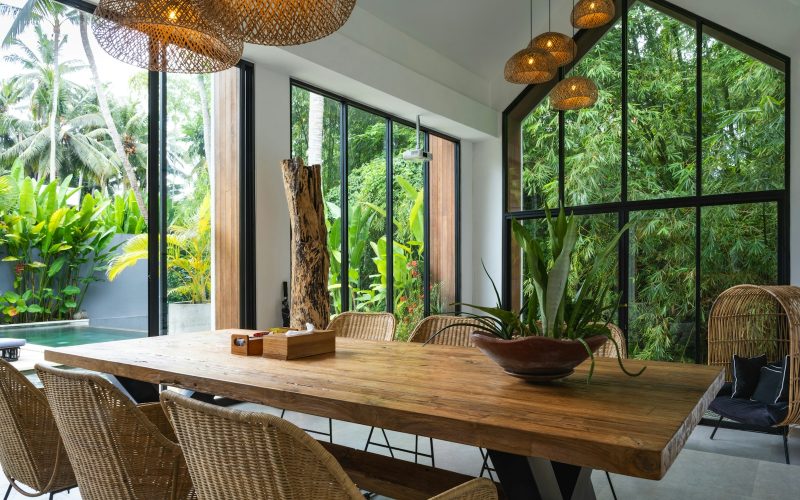 A dining room with a large wooden table surrounded by chairs