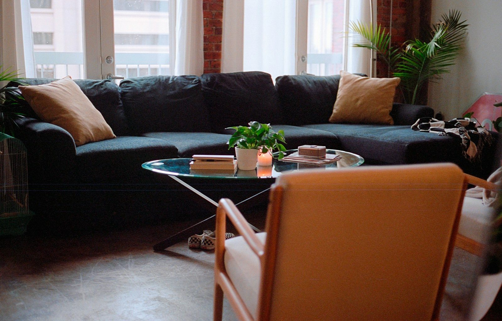 a living room with a couch, chair, table and potted plant