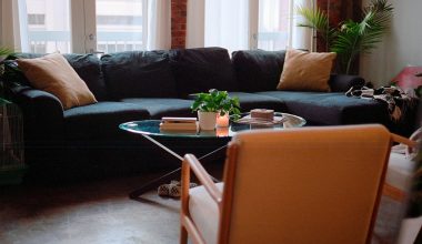 a living room with a couch, chair, table and potted plant