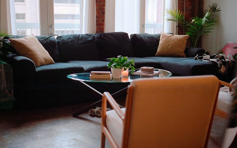 a living room with a couch, chair, table and potted plant