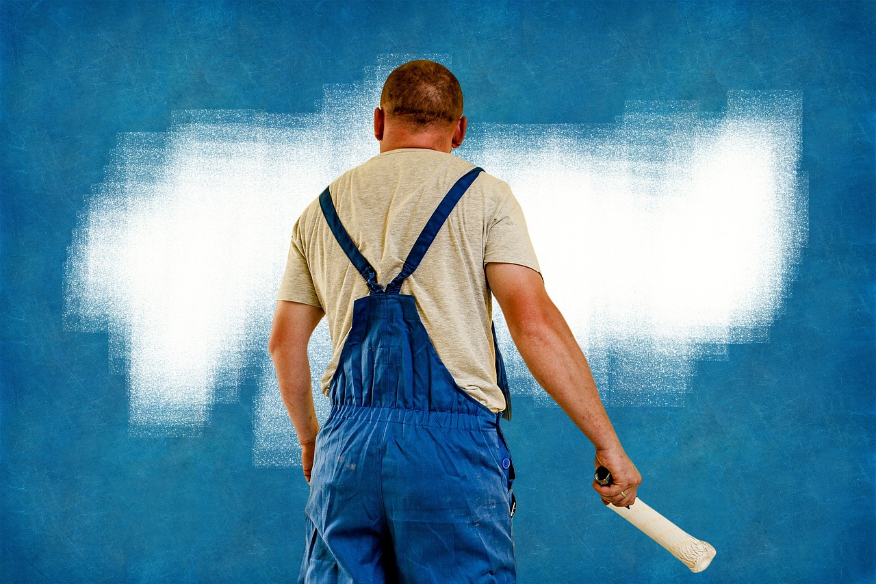 Schilder die een muur wit verft met een roller
