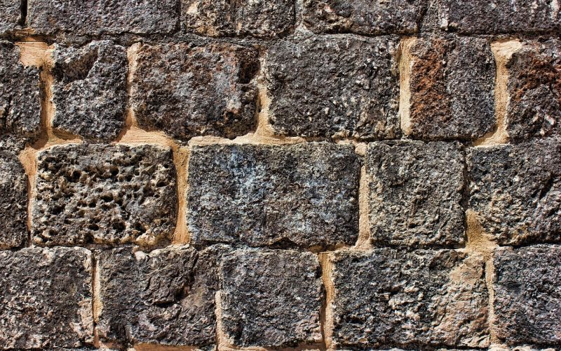 Stapelblokken in een tuin gebruikt als keermuur langs een border
