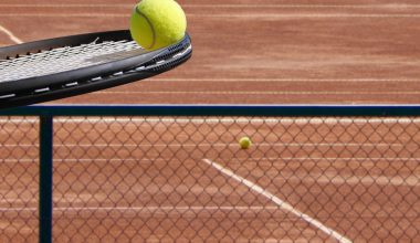 Twee spelers op een padelcourt spelen een rally op kunstgras