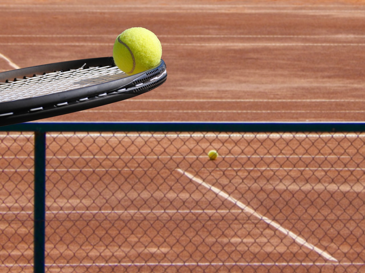Twee spelers op een padelcourt spelen een rally op kunstgras