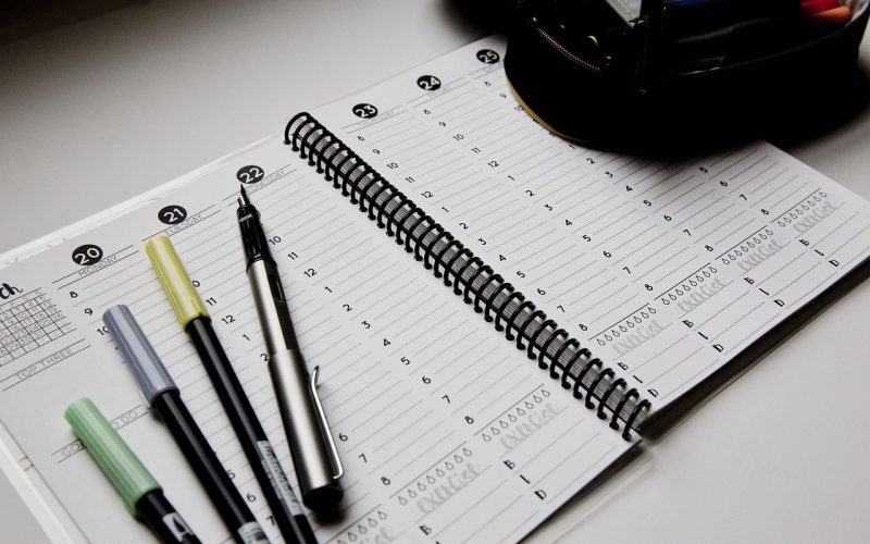 Gezin bij een weekplanner in de keuken met meerdere schoolroosters