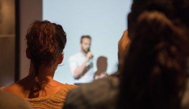 Persoon die zelfverzekerd een presentatie geeft voor een groep collega's in een vergaderzaal