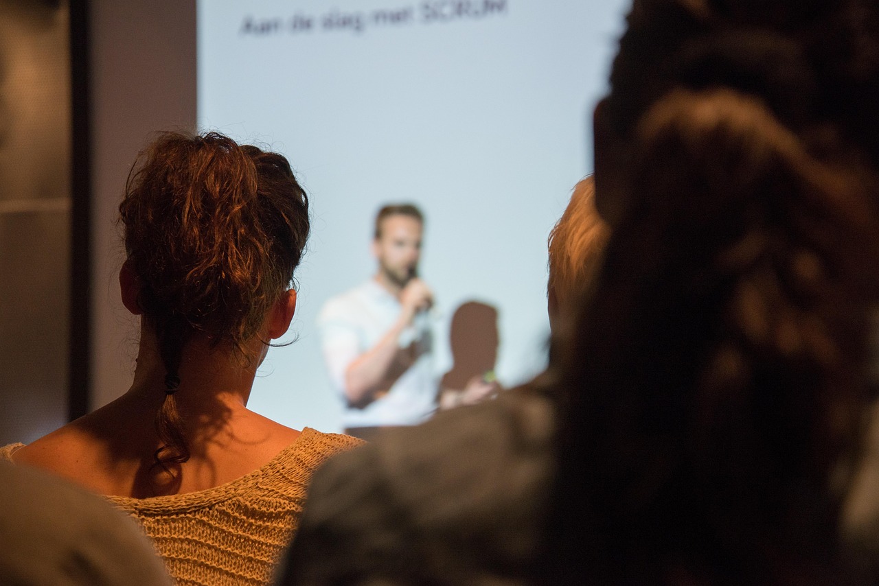Persoon die zelfverzekerd een presentatie geeft voor een groep collega's in een vergaderzaal