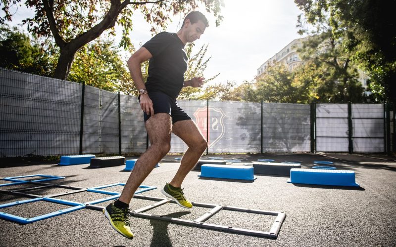 Een sporter die buiten traint met minimale middelen, zoals lichaamsgewicht en een betonnen ondergrond