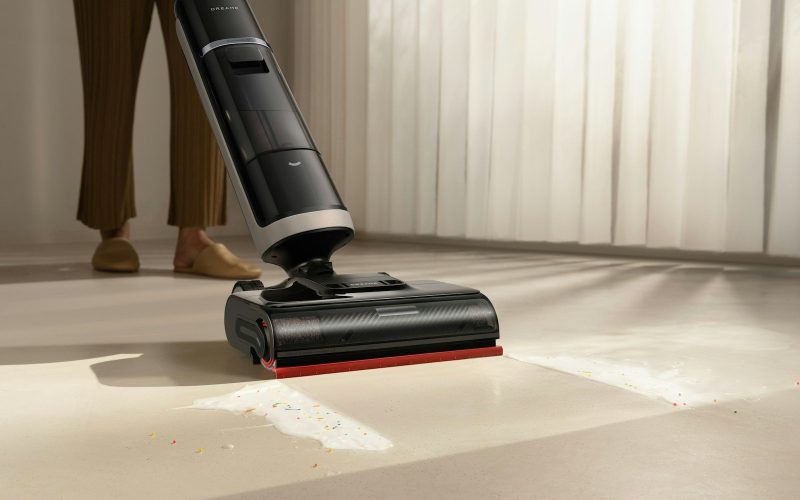 A person using a cordless vacuum cleaner on a floor