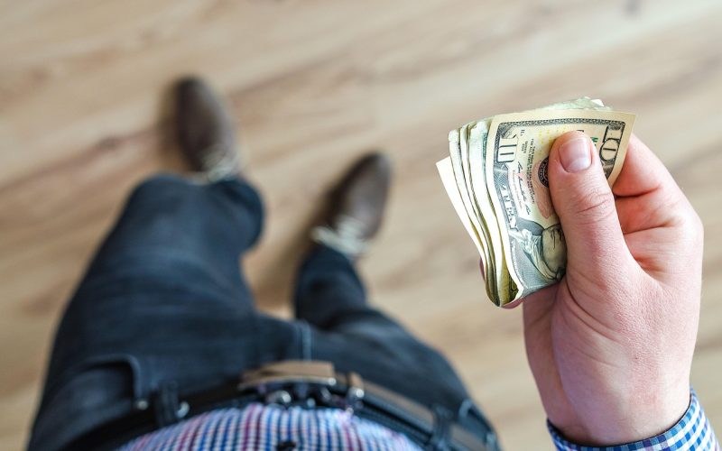 Persoon die zijn financiën overziet aan tafel met papieren en een pen