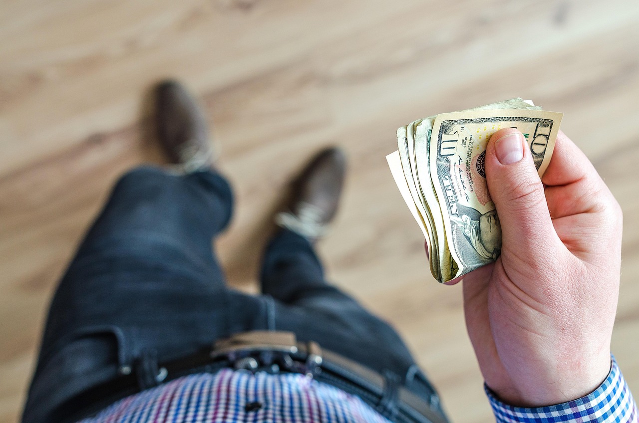Persoon die zijn financiën overziet aan tafel met papieren en een pen